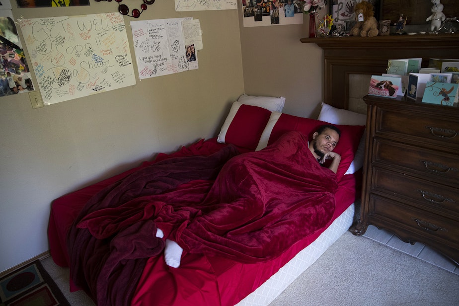 caption: DaShawn Horne rests in his newly converted bedroom on the first floor shortly after arriving home from spending 103 days at hospital, on Thursday, May 3, 2018, at their home in Auburn.