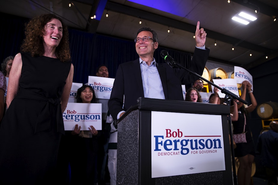 caption: Bob Ferguson, the Democrat gubernatorial candidate for Washington state, arrives to a cheering crowd during a primary election night party on Tuesday, August 6, 2024, at Reuben’s Barrel House event space in Seattle.