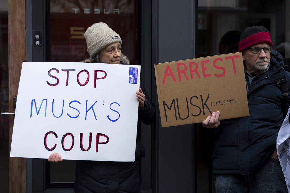 caption: The Troublemakers group protested in front of the Tesla showroom in South Lake Union on Thursday, Feb. 13, 2025, in Seattle.