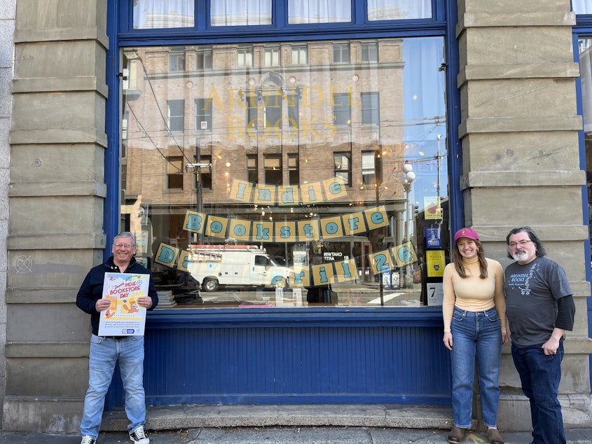 caption: Phil Bevis, Molli Corcoran, and Vladimir Verano outside their Arundel Books store in Seattle's Pioneer Square neighborhood.