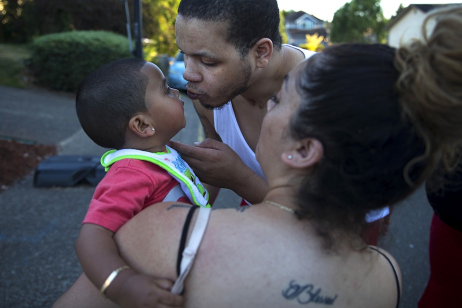 caption: DaShawn Horne kisses his son Deion, now 2, held by his mother Vanessa, on Thursday, July 26, 2018, after playing basketball in front of the Horne's home in Auburn.
