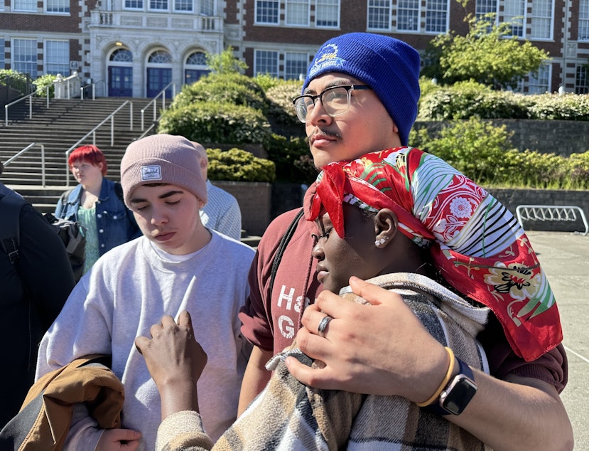 caption: Former Garfield High School student Karima Souleyman is comforted by friends. Souleyman spoke at a community gathering outside school on the morning after a student was fatally shot on campus.