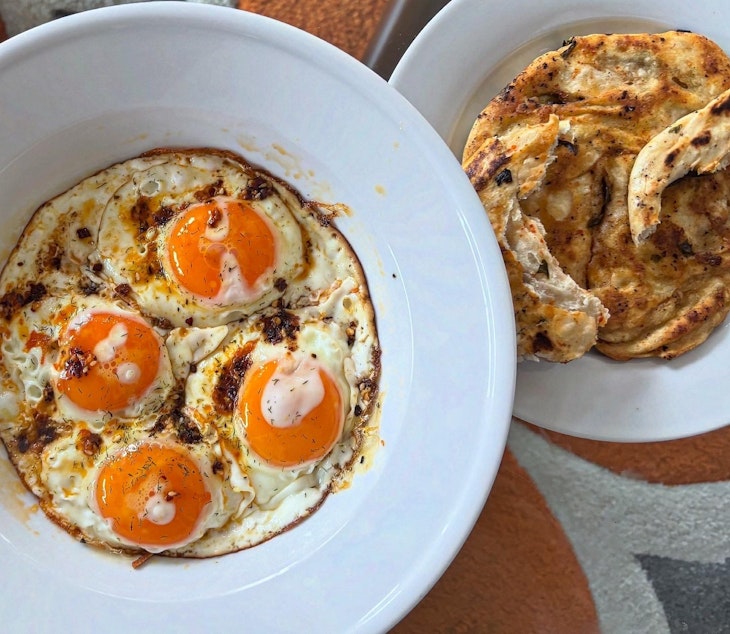 caption: KUOW Book Club guide Katie Campbell serves scallion pancakes alongside a plate of eggs fried in chili oil. The KUOW Book Club is reading and cooking with "Feasts of Good Fortune" by Hsiao-Ching Chou and Meilee Chou Riddle this month.
