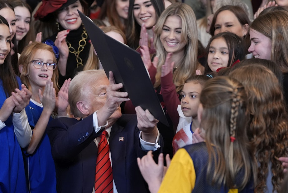 caption: President Donald Trump holds up a signed executive order barring transgender female athletes from competing in women's or girls' sporting events, in the East Room of the White House, Wednesday, Feb. 5, 2025, in Washington.