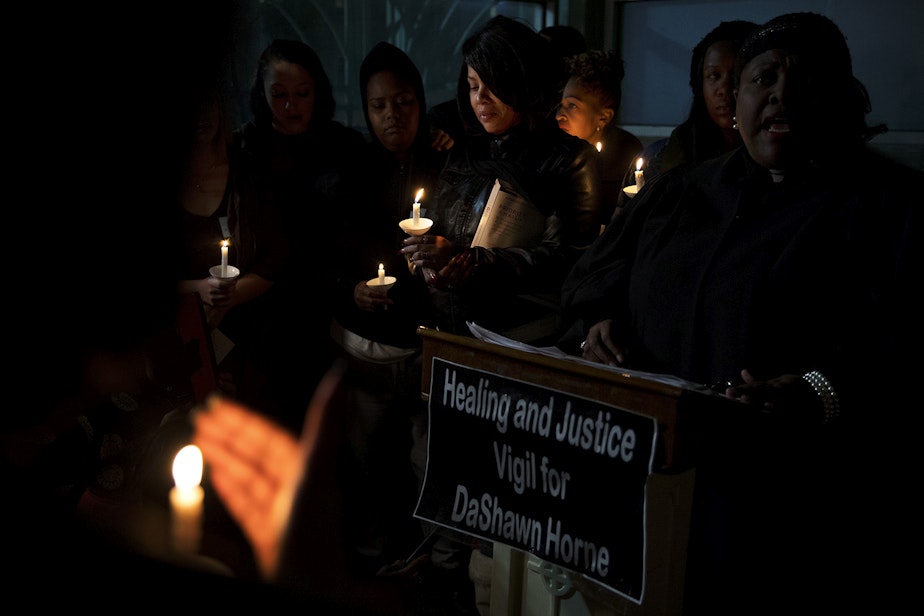caption: LaDonna Horne, center, holds a candle during a healing and justice vigil for her son, DaShawn Horne, on Saturday, February 3, 2018, outside of the hospital at Harborview Park in Seattle.