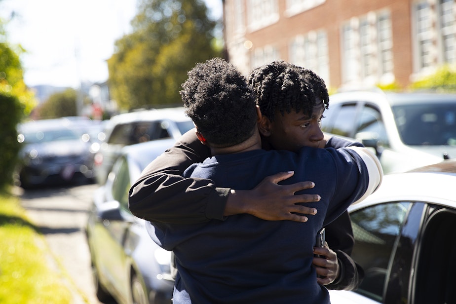 caption: Christle Young hugs her son after he was released from school following a deadly shooting of a student on Thursday, June 6, 2024, at Garfield High School in Seattle.