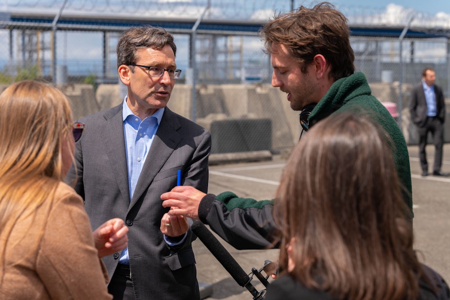 caption: Gov. Bob Ferguson at Terminal 46 in Seattle talking about his official pen with KUOW's Scott Greenstone.