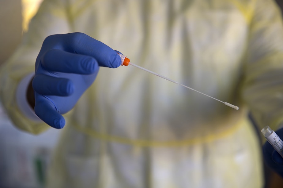 caption: Richard Vialva, a medical assistant with International Community Health Services, holds a coronavirus testing swab on Thursday, April 16, 2020, at the ICHS testing area in Shoreline. "Our whole country is filled with people who are unsure of their status or can't get tested," said Vialva. "I hope we're giving people some relief."