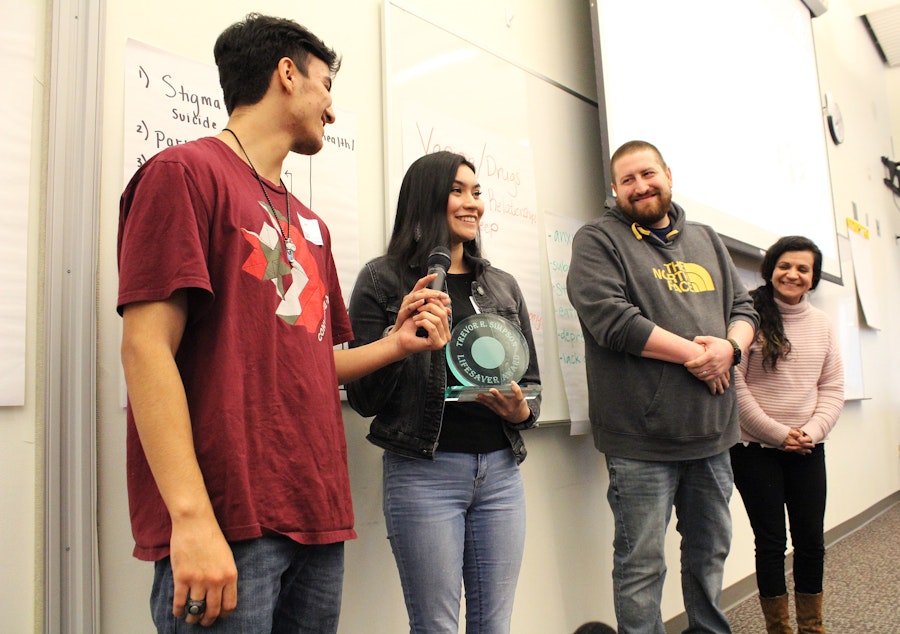 caption: From left: Seniors Dominic Jansen and Raven Stevenson, accompanied by advisers Andrew Burdette and Crissie Petro, accept the Trevor R. Simpson Award for their work as peer mentors at the Muckleshoot Tribal School.