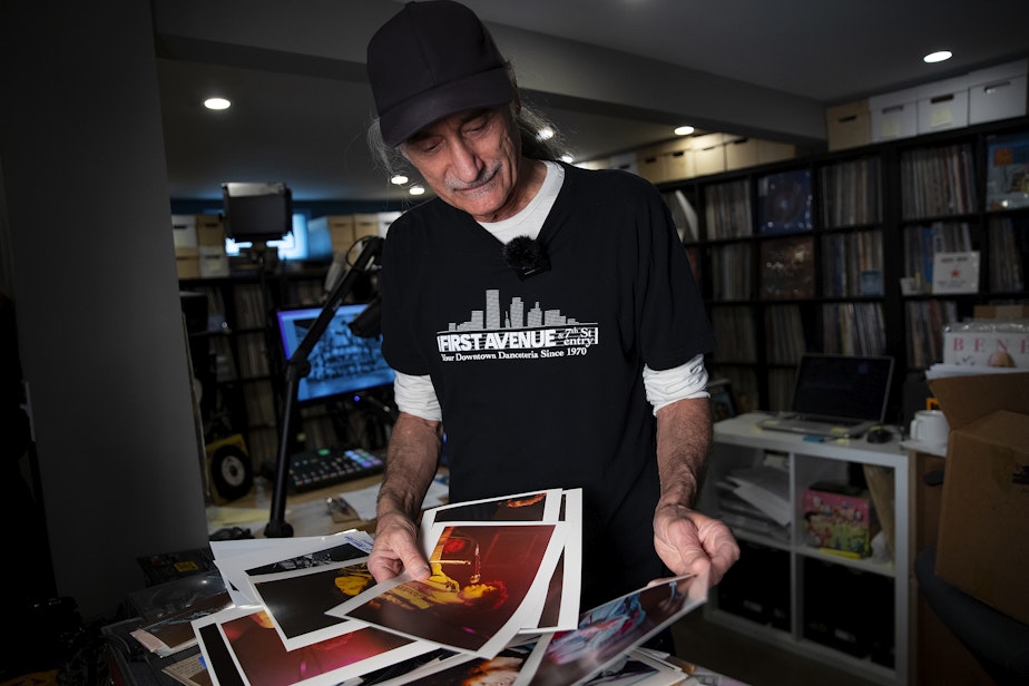 caption: Retiring KEXP DJ Kevin Cole looks through a box of Prince memorabilia at his home studio on Monday, July 8, 2024, in Seattle.