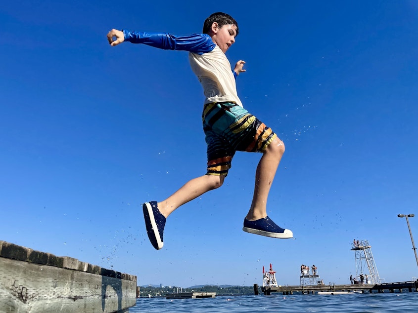 caption: Pablo, 9, jumps into the waters of Lake Washington in September.