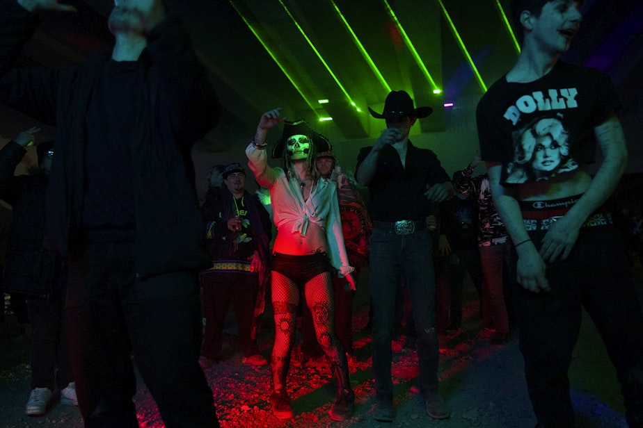 caption: Fiona Carpenter, 20, dances with others during a renegade rave under a bridge on Friday, October 18, 2024, in Seattle.
