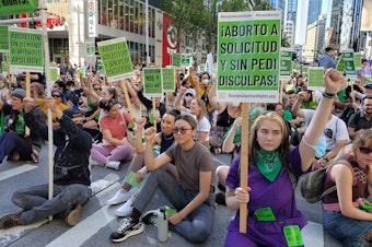 caption: A group of people protests the Supreme Court of the United States decision to overturn Roe v. Wade