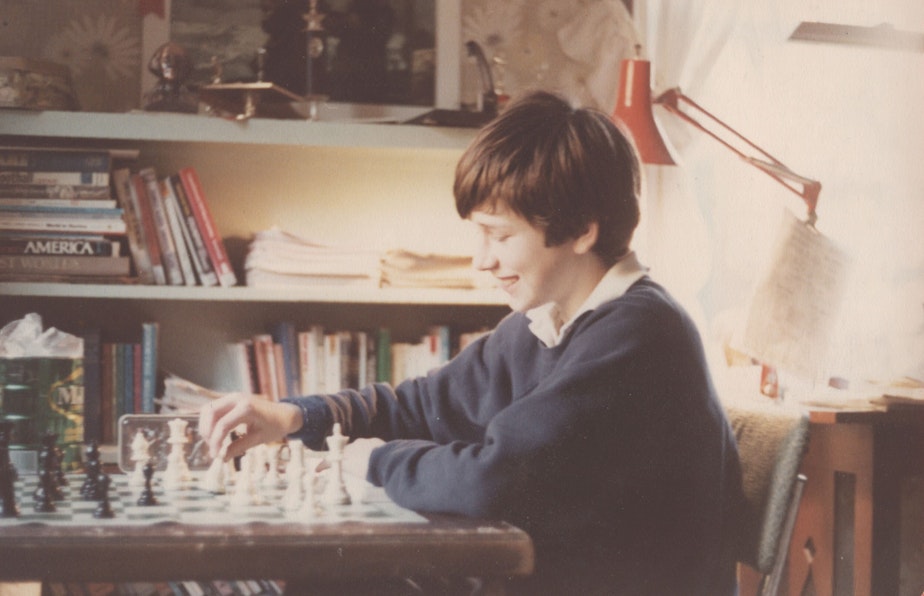 caption: Bob Ferguson playing chess as a child in his bedroom.