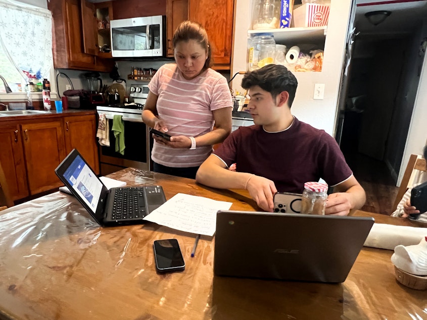 caption: Leticia Villatoro, left, and her 17-year-old son Alex juggle between screens to figure out where her husband and his father, Armando Chaj, was being held by immigration officials, and whether he had been deported to Guatemala.