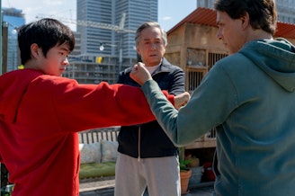 caption: (L-R) Ben Wang, Jackie Chan, and Ralph Macchio star in 2025's "Karate Kid: Legends."