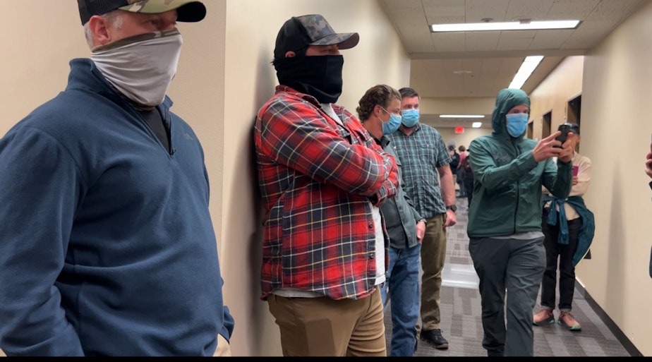 caption: Suspected agents with the U.S. Immigration and Customs Enforcement line the hallway outside a courtroom at the Seattle Immigration Court Wednesday.