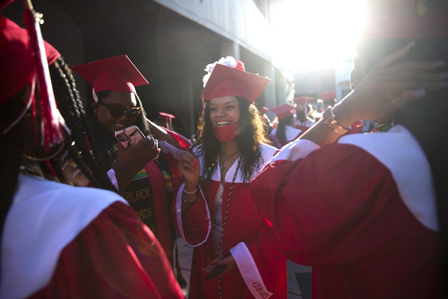 caption: Cleveland Stem High School senior Parris Sanjose laughs with classmates before the in-person commencement ceremony on Tuesday, June 15, 2021, at Memorial Stadium in Seattle.