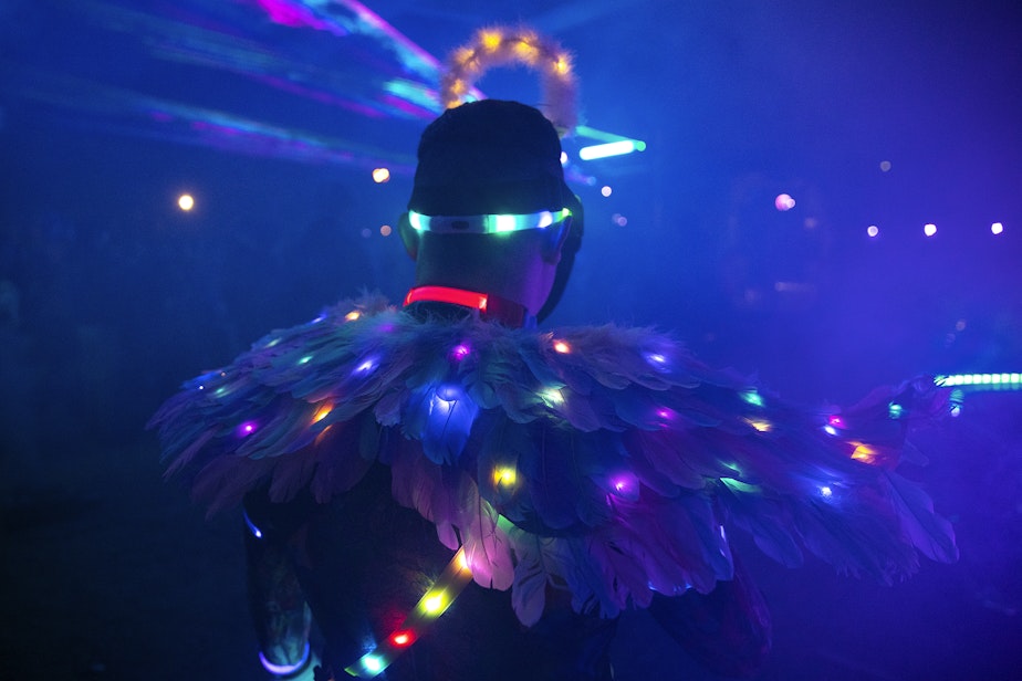 caption: Kevin Hernandez, known as HAPPYTEARS, wears light up wings during a renegade rave under a bridge, on Friday, October 11, 2024, in Seattle.