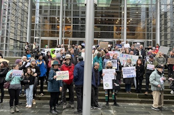 caption: Supporters of refugee resettlement stand before the federal courthouse in Seattle on Feb. 25, 2025. 