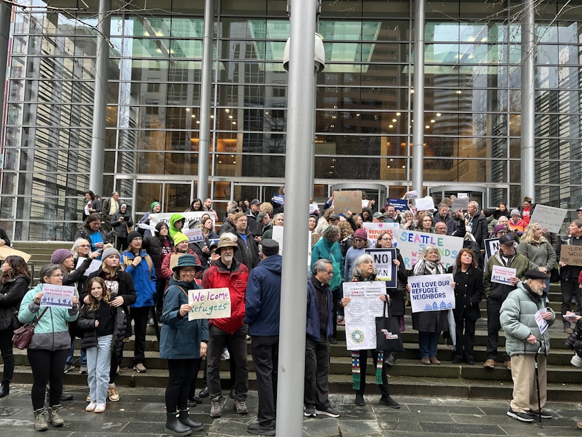 caption: Supporters of refugee resettlement stand before the federal courthouse in Seattle on Feb. 25, 2025.