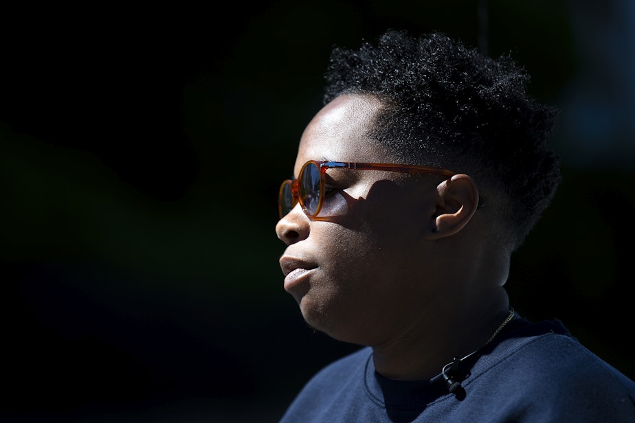caption: Christle Young is interviewed by a news outlet while waiting for her son to be released from school following a shooting on Thursday, June 6, 2024, at Garfield High School in Seattle.