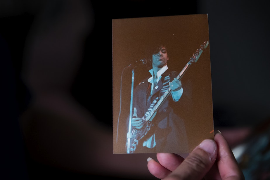 caption: Angela King holds a photograph of Prince while looking through a box of memorabilia in Kevin Cole’s home studio on Monday, July 8, 2024, in Seattle.