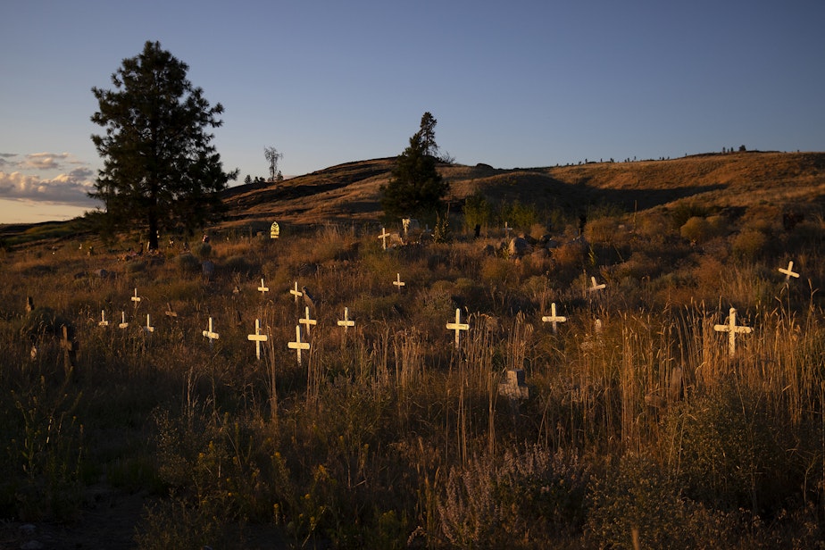 caption: Unmarked graves are shown behind St. Mary’s Catholic Mission on Thursday, July 20, 2017, in Omak.