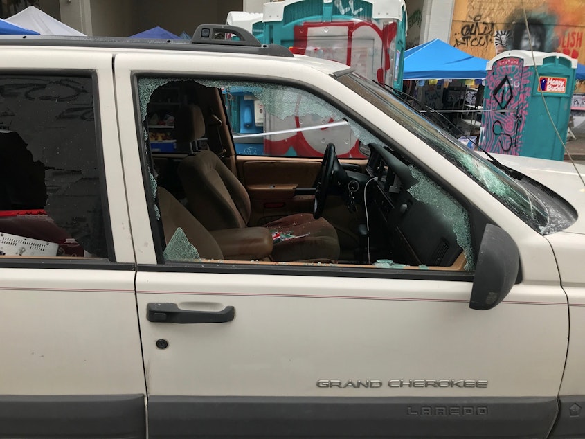 caption: A car sits in the Capitol Hill Organized Protest zone following a shooting in Seattle early Monday, June 29, 2020. At least one man was killed and another was wounded early Monday morning when they were shot in the protest area known as CHOP, after driving the vehicle into the area.