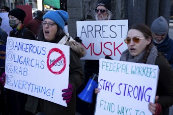 caption: A crowd gathers outside of the Jackson Federal Building for a rally to ‘save the civil service,’ on Tuesday, February 11, 2025, in Seattle. 