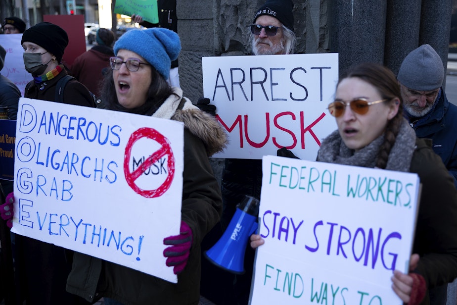 caption: A crowd gathers outside of the Jackson Federal Building for a rally to ‘save the civil service,’ on Tuesday, February 11, 2025, in Seattle.