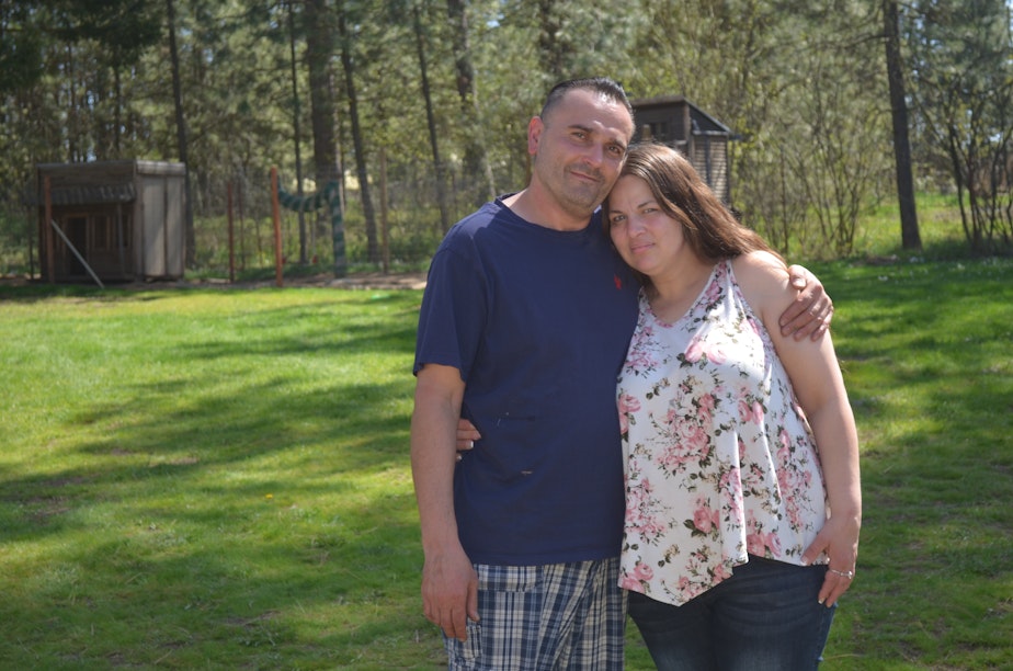 caption: Sergey Kostenyuk and Mary Loisate are portrayed outside their home on the outskirts of Spokane.