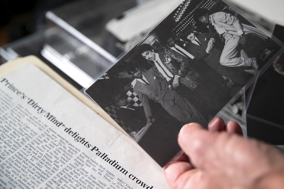 caption: Retiring KEXP DJ Kevin Cole looks through a box of Prince memorabilia at his home studio on Monday, July 8, 2024, in Seattle.