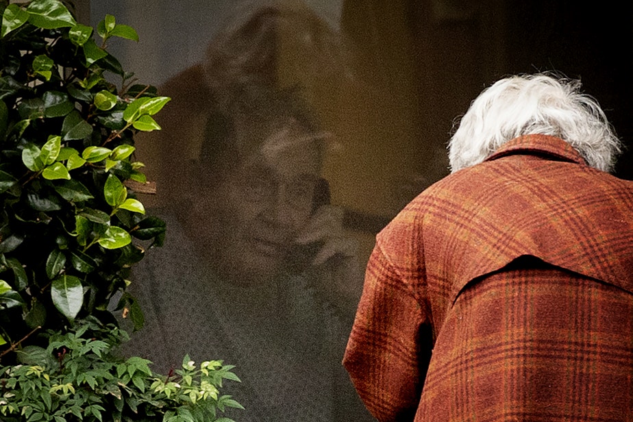 caption: Dorothy Campbell talks to her husband, Gene Campbell, on the phone through his window at the Life Care Center of Kirkland on Thursday, March 5, 2020, in Kirkland. Dorothy's son Charlie Campbell came from Silver City, New Mexico, to bring his mother to see his father. "It’s kind of tough but it’s the best we can do at this point," he said.