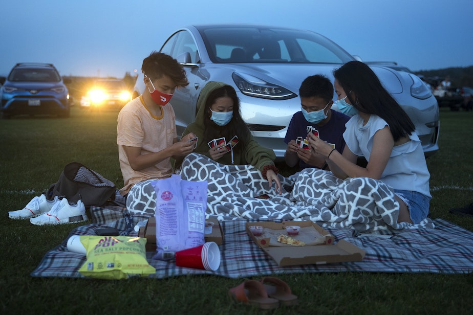 caption: From left, friends Nile, Julia, Ben and Catherine play UNO while waiting for Men In Black to begin on Tuesday, August 18, 2020, at the drive-in theater at Marymoor Park in Redmond.
