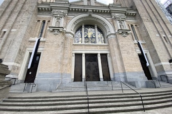 caption: The front entrance of St. James Cathedral in Seattle displays black and white bunting following the death of Pope Francis on April 21, 2025.