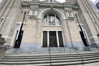 caption: The front entrance of St. James Cathedral in Seattle displays black and white bunting following the death of Pope Francis on April 21, 2025.