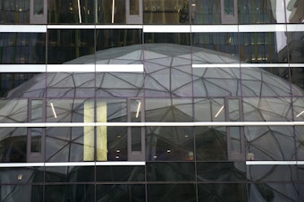 caption: The Amazon Spheres are reflected in the Amazon Doppler building on Monday, January 29, 2018, during the spheres grand opening in Seattle. 