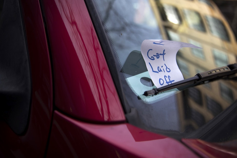 caption: A piece of paper meant to look like a previously issued parking ticket is shown under the windshield wiper of a vehicle with a handwritten note reading 'I got laid off,' on Tuesday, March 17, 2020, on Ballard Avenue Northwest in Seattle.