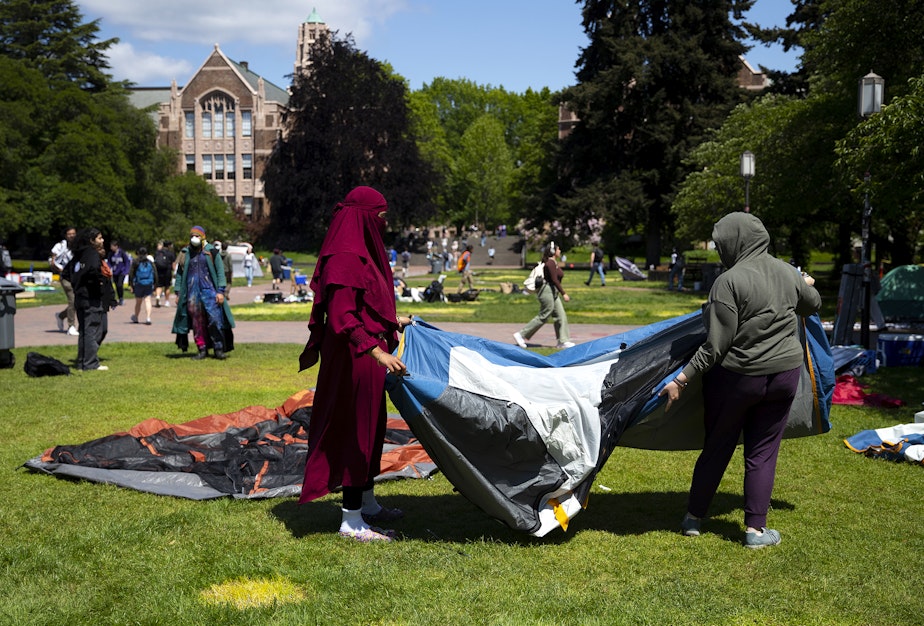 caption: University of Washington students who did not want to be identified by name take down a tent ahead of the 3 p.m. deadline for protesters to remove the pro-Palestinian encampment on Monday, May 20, 2024, on the campus Quad in Seattle.
