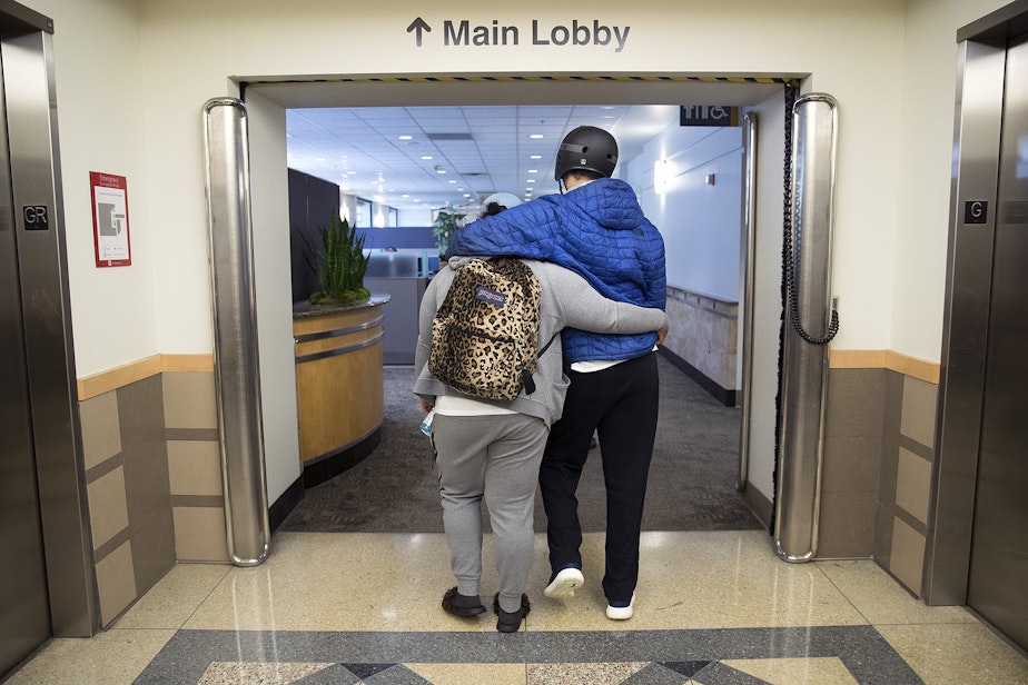 caption: Da'Nesha Mitchell, 24, walks with her arm around her brother, DaShawn Horne, after a physical therapy appointment on Wednesday, June 13, 2018, at Harborview Medical Center in Seattle.