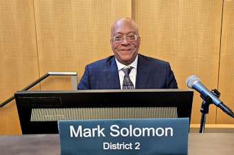 caption: Newly appointed Seattle City Councilmember Mark Solomon takes his seat on the dais. 
