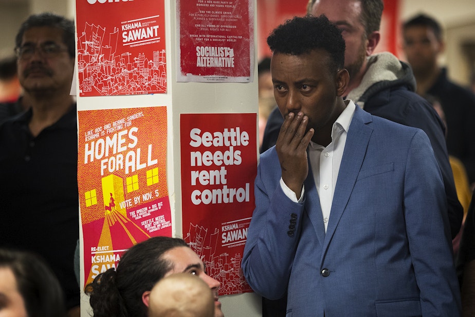 caption: Hassan Diis reacts as early election results show councilmember Kshama Sawant trailing behind her District 3 opponent Egan Orion on Tuesday, November 5, 2019, during an election night party at Langston Hughes Performing Arts Institute in Seattle.
