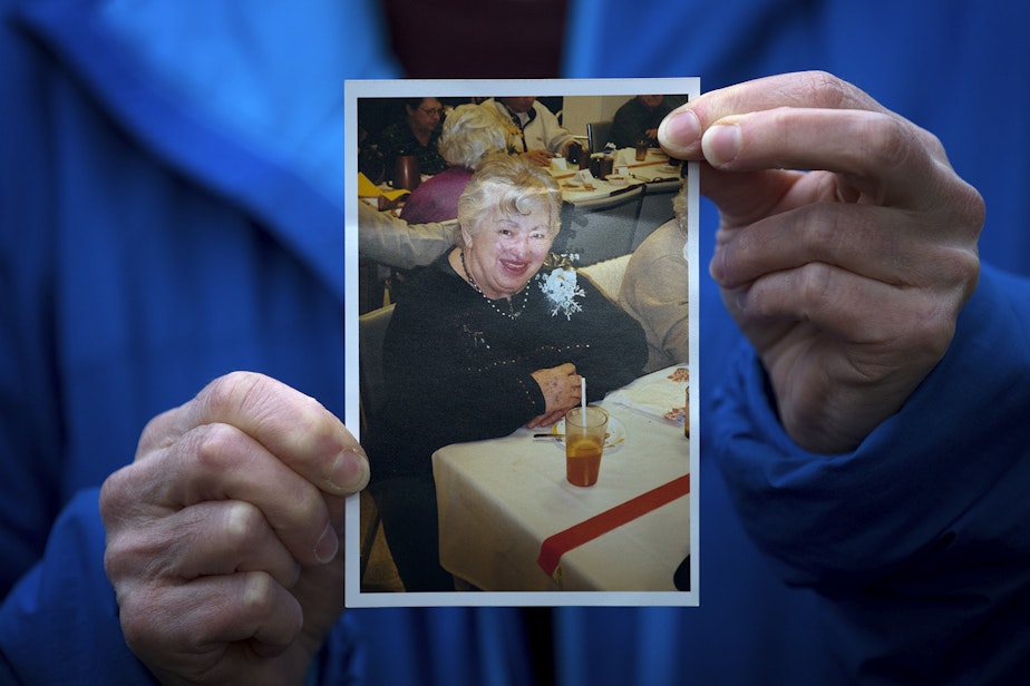 caption: Pat Herrick holds a picture of her 89-year-old mother, Elaine Herrick, at the Life Care Center of Kirkland on Thursday, March 5, 2020, in Kirkland. Elaine Herrick had died early Thursday morning while in the care of Life Care Center amid a deadly COVID-19 outbreak. Seven hours after learning of her mother's death, Pat Herrick received a call from Life Care: her mother was doing great. She had no fever and was showing no symptoms of COVID-19. Herrick alerted them of her mother's death.