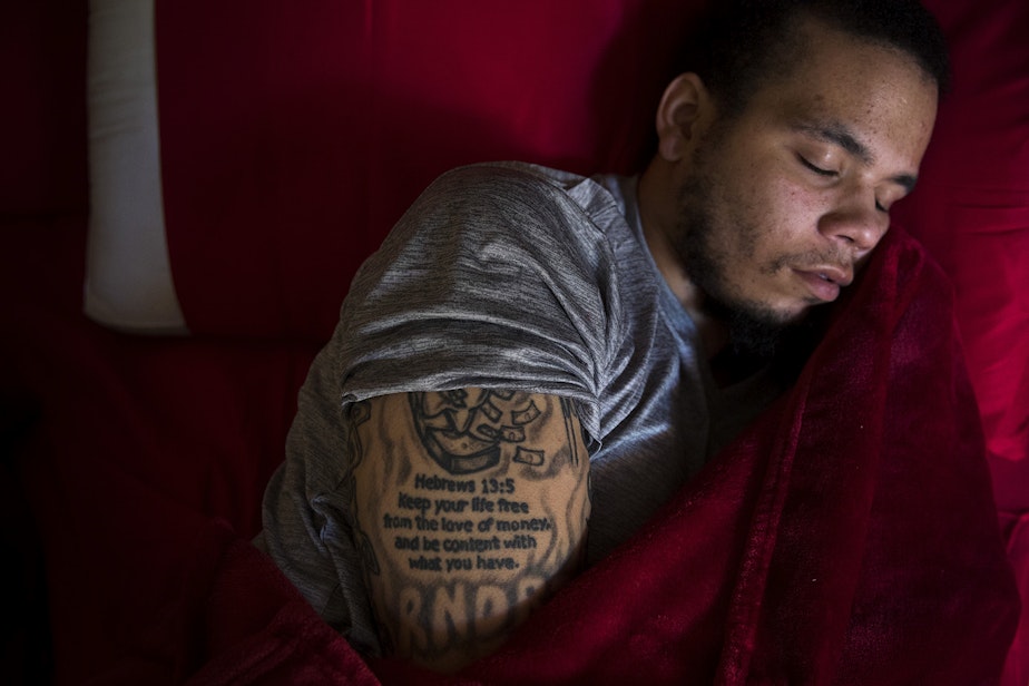 caption: DaShawn Horne rests in his new bedroom on the first floor shortly after arriving home from spending 103 nights at Harborview Medical Center, on Thursday, May 3, 2018, at his home in Auburn.