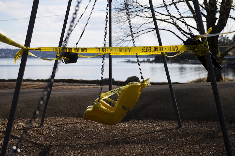 caption: A swing set is shown off limits and surrounded by caution tape as a result of the coronavirus outbreak on Wednesday, March 25, 2020, at Seward Park in Seattle.