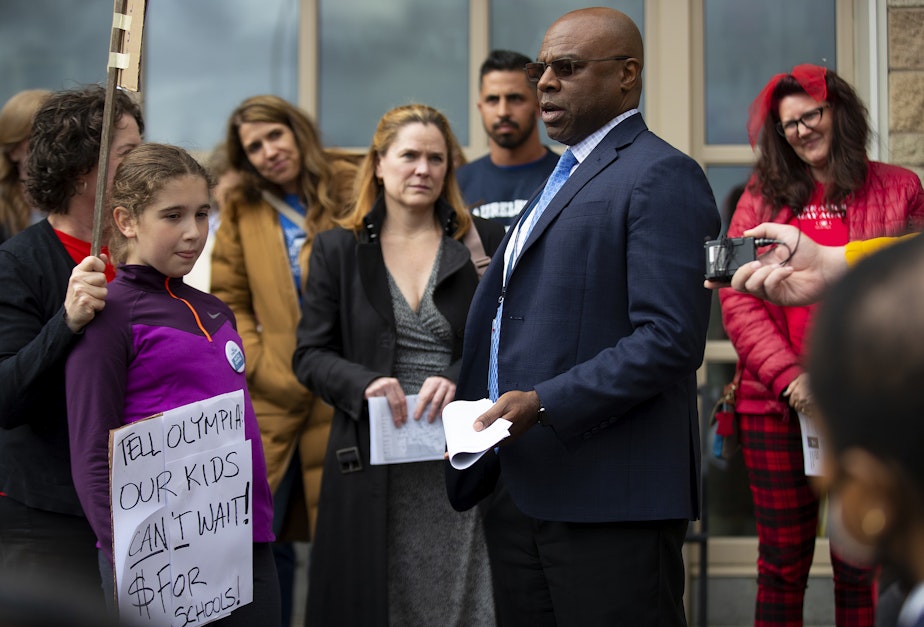 caption: Parents confront Seattle Public Schools Superintendent Brent Jones before a meeting about the proposed closure of 20 elementary schools on Tuesday, May 28, 2024, at Roosevelt High School in Seattle.