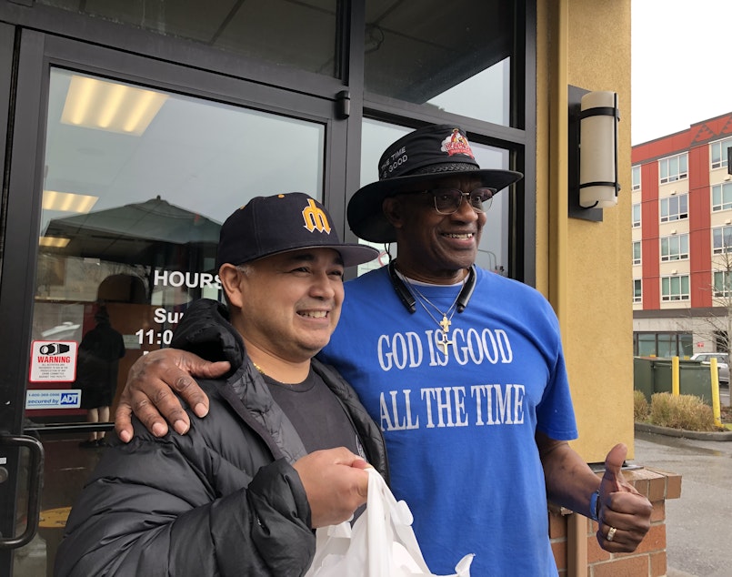 caption: Longtime customer Phillip Orquia, left, poses with Ezell Stephens in Lake City, February 24, 2025.