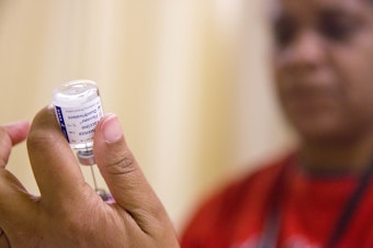 caption: FILE - In this Wednesday, Feb. 7, 2018 file photo, a nurse prepares a flu shot from a vaccine vial at the Salvation Army in Atlanta. 