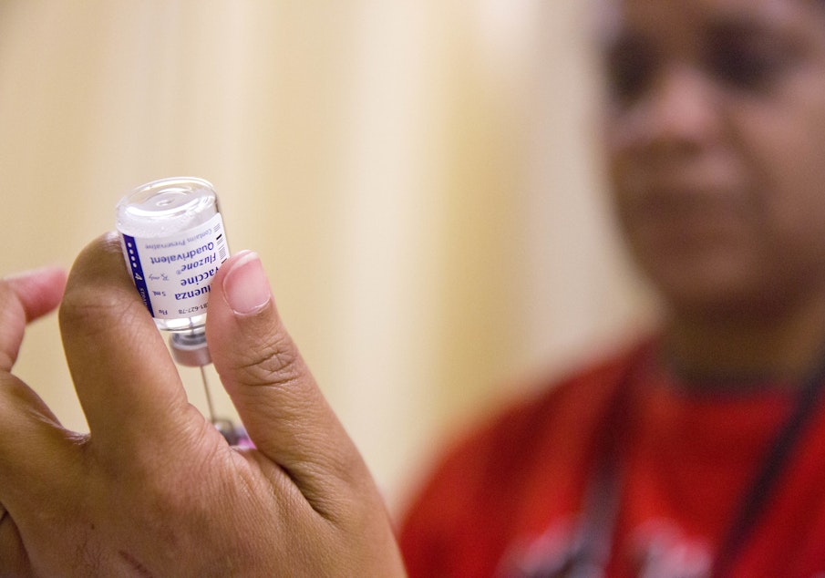 caption: FILE - In this Wednesday, Feb. 7, 2018 file photo, a nurse prepares a flu shot from a vaccine vial at the Salvation Army in Atlanta.